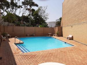 a large blue swimming pool with a brick wall at 305 Hawaan View in Durban