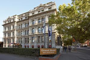 Un gran edificio blanco con un cartel delante. en Grand Hotel Melbourne, en Melbourne