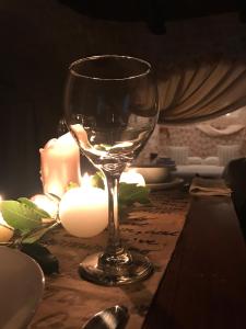 un bicchiere di vino seduto su un tavolo con candele di Trulli Aria di Casa ad Alberobello