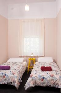 2 łóżka w małym pokoju z oknem w obiekcie The Cally Hotel w mieście Warrnambool