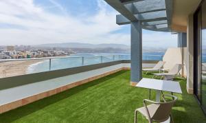a balcony with chairs and a view of the ocean at NH Imperial Playa in Las Palmas de Gran Canaria