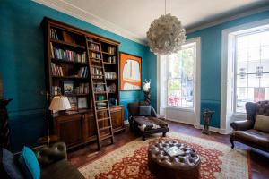 a living room with blue walls and a book shelf at Cape Heritage Hotel in Cape Town