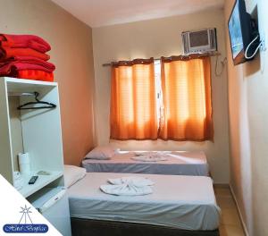 a small room with two beds and a window at Hotel Benfica in Aparecida