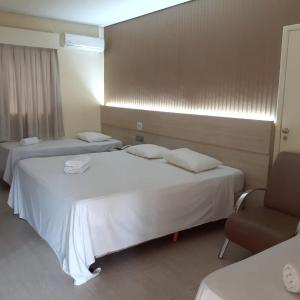 una habitación de hotel con 2 camas y una silla en Campo Belo Resort en Álvares Machado
