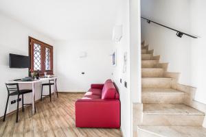 a living room with a red couch and a table at Borgo Aureo in Rome