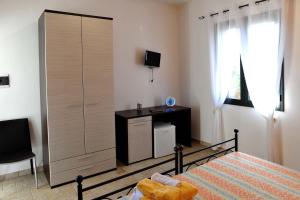 a bedroom with a bed and a cabinet and a desk at Agriturismo Caranna in Torre Lapillo