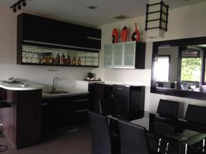 uma cozinha com armários a preto e branco e cadeiras pretas em Hollywood Drive-In Hotel em Baguio