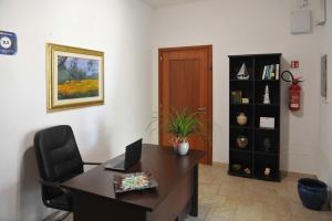 ein Büro mit einem Schreibtisch, einem Stuhl und einem Bücherregal in der Unterkunft Agriturismo Caranna in Torre Lapillo