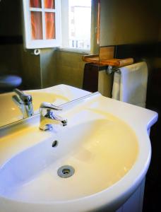 a white sink in a bathroom with a window at Villa Arazurrina in Cagliari