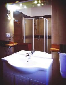 a bathroom with a white sink and a mirror at Villa Arazurrina in Cagliari