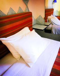- un lit avec des oreillers blancs dans une chambre d'hôtel dans l'établissement Villa Arazurrina, à Cagliari