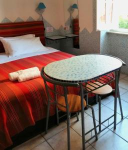 une table et une chaise en face d'un lit dans l'établissement Villa Arazurrina, à Cagliari