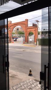 an empty street with an arch in the background at Portal Palace Hotel in Aparecida