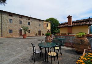a patio with a table and chairs and a building at I Sette Borghi in Massa e Cozzile