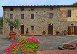 a stone building with flowers in front of it at I Sette Borghi in Massa e Cozzile