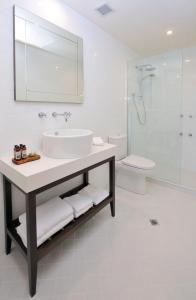 a bathroom with a sink, toilet and bathtub at Grand Hotel Melbourne in Melbourne