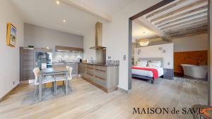 1 dormitorio con 1 cama y cocina con mesa en Maison de Save, en LʼIsle-Jourdain