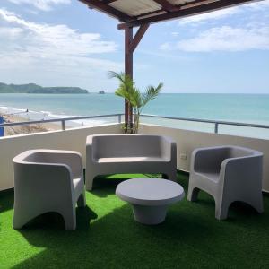 Hotel Andy في أتاكاميس: شرفة مع طاولة وكراسي والشاطئ
