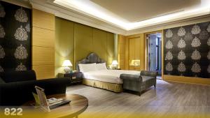 una camera d'albergo con letto e sedia di Wehome Motel a Tainan