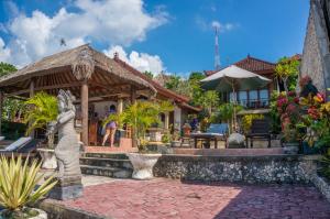 una casa con una statua di fronte di Oka 7 Bungalow a Nusa Lembongan