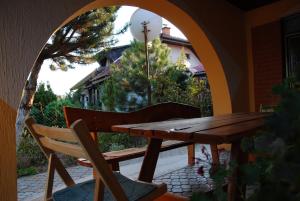 einen Holztisch und einen Stuhl auf einer Terrasse in der Unterkunft Vila Verona Sobe in Palić
