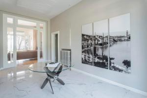 a living room with a glass table and a tv at Villa Belvedere in Salò