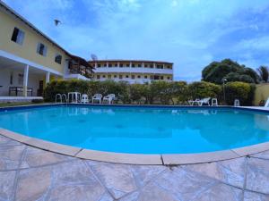 a large swimming pool in front of a building at Pousada Gira-Sol in São Pedro da Aldeia