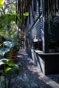 a cobblestone sidewalk next to a building with plants at Maka Hotel Boutique in Tulum