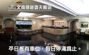 a hotel lobby with a reception desk and a television at 文南哥爸妻夫飯店 in Tainan