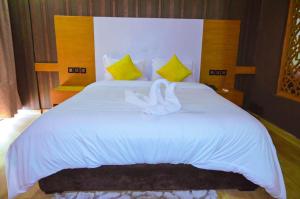 a large white bed with two white towels on it at Hotel SAHARATEL in Laayoune