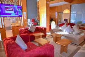 a living room with two couches and a tv at Hotel SAHARATEL in Laayoune +14 photos
