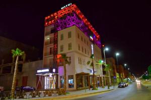 a building with lights on the side of it at night at Hotel SAHARATEL in Laayoune