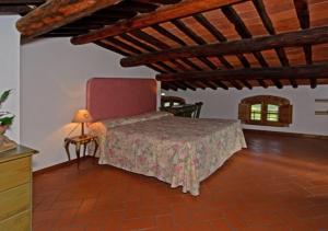 1 dormitorio con 1 cama y 1 mesa con lámpara en I Sette Borghi, en Massa e Cozzile