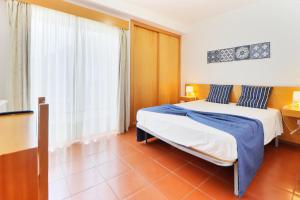 a bedroom with two beds and a large window at Aparthotel Gerês in Geres