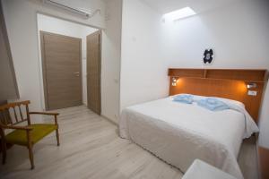 sypialnia z łóżkiem, krzesłem i drzwiami w obiekcie Casa Terranova Modica w mieście Modica