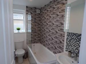 a bathroom with a tub and a toilet and a sink at City Beach AirBnB Southend on Sea, in Southend-on-Sea