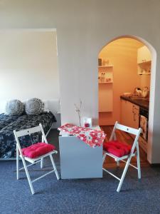 two chairs and a table in a room with a bed at студио Маргрете in Burgas City
