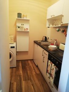 a small kitchen with a sink and a dishwasher at студио Маргрете in Burgas