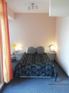 a bedroom with a bed with a black and blue bedspread at студио Маргрете in Burgas