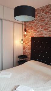ein Schlafzimmer mit einem Bett und einer Ziegelwand in der Unterkunft Active Residence C 408 in Lublin