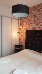 a bedroom with a bed and a brick wall at Active Residence C 408 in Lublin