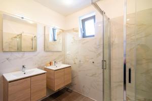 a bathroom with two sinks and a shower at Villa La Via *** in Dunajská Streda