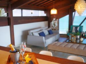 a living room with a table with wine glasses and a couch at Pousada Ecos Beach in Porto De Galinhas +105 photos