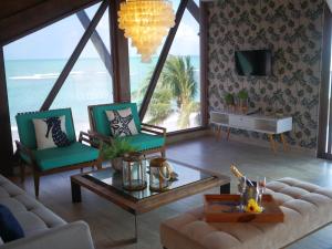 a living room with a couch and chairs and a table at Pousada Ecos Beach in Porto De Galinhas