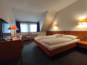 Habitación de hotel con cama grande y escritorio. en Condi Hotel, en Hamburgo