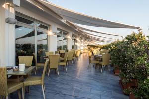a restaurant with tables and chairs on a patio at Barion Hotel & Congressi in Bari