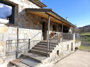 a stone house with a staircase in front of it at Mas Can Cels in Sant Pau de Segúries