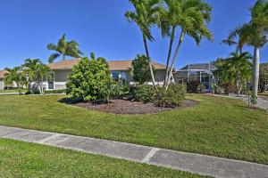 a house with palm trees in front of a yard at Sunny Marco Island Oasis Less Than 2 Miles to Beach! in Marco Island