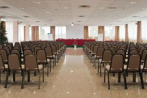 an empty room with chairs and a red couch at Barion Hotel & Congressi in Bari
