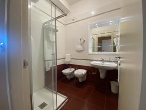 a bathroom with two toilets and a sink and a shower at Barion Hotel & Congressi in Bari